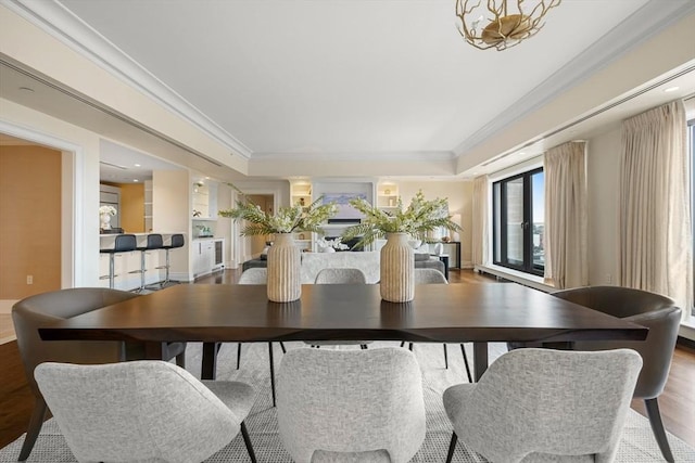 dining room with french doors, crown molding, and wood finished floors