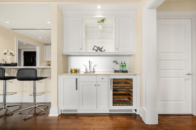 bar featuring dark wood-type flooring, beverage cooler, a sink, recessed lighting, and indoor wet bar