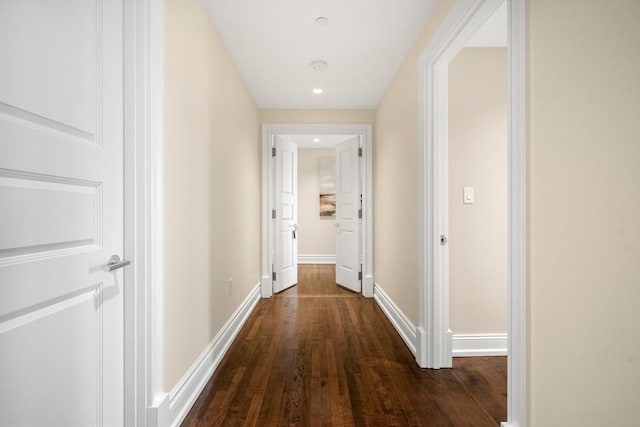 corridor featuring baseboards and wood finished floors