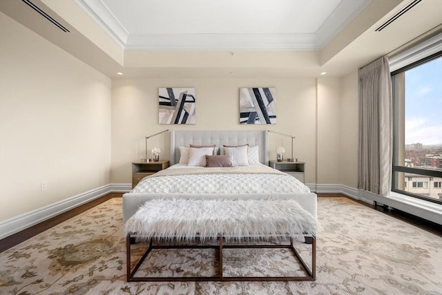 bedroom featuring a tray ceiling, visible vents, and ornamental molding