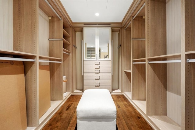 spacious closet with attic access and wood finished floors