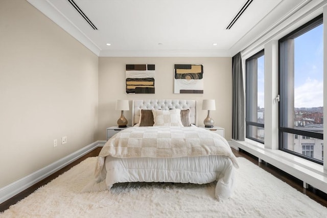 bedroom with baseboards, wood finished floors, ornamental molding, and access to exterior