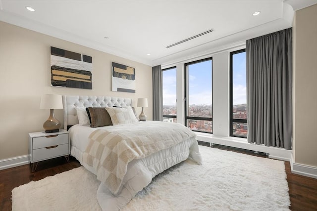 bedroom featuring baseboards, wood finished floors, and ornamental molding