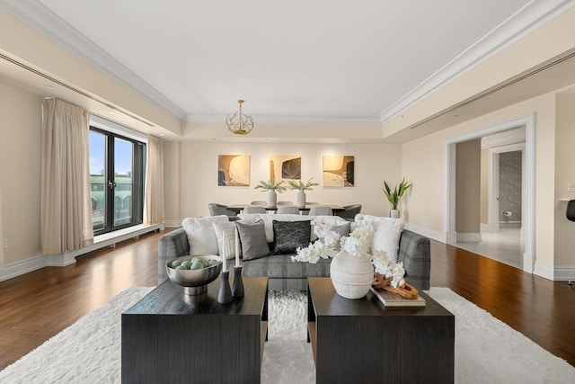 living area featuring crown molding, wood finished floors, and baseboards