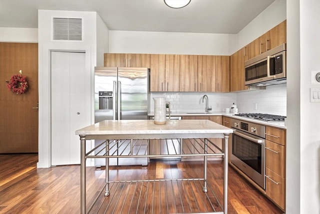 45 1st Ave Unit 301, Boston, MA 02129 - kitchen featuring appliances with stainless steel finishes, a sink, light countertops, dark wood-style flooring, and tasteful backsplash