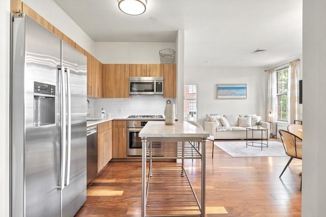 45 1st Ave Unit 301, Boston, MA 02129 - kitchen with appliances with stainless steel finishes, light countertops, open floor plan, hardwood / wood-style flooring, and tasteful backsplash