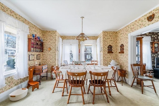 carpeted dining space with a chandelier and ornamental molding