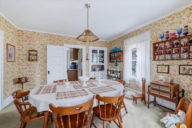 dining area with crown molding, a chandelier, and light carpet