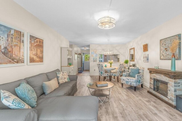 79 Chilton Ln Unit 79, Brewster, MA 02631 - living area with a stone fireplace, light wood-type flooring, and baseboards