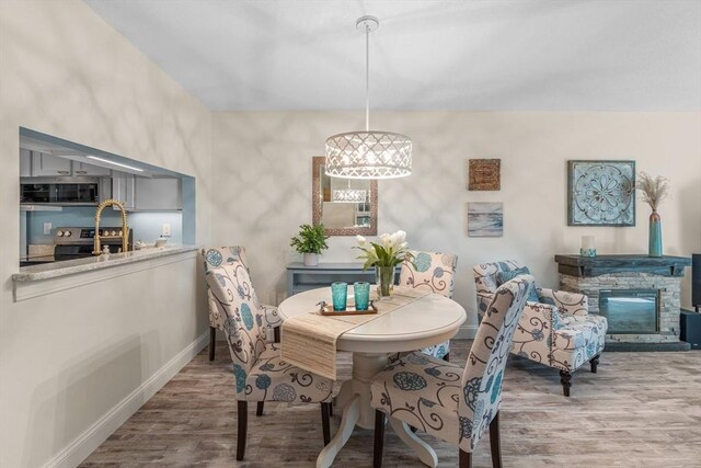 79 Chilton Ln Unit 79, Brewster, MA 02631 - dining area with wood finished floors, baseboards, and a stone fireplace