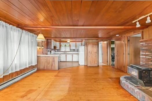 10 Sandpiper Ter, Wareham, MA 02571 - kitchen featuring a wood stove, wooden ceiling, baseboard heating, freestanding refrigerator, and light wood-type flooring
