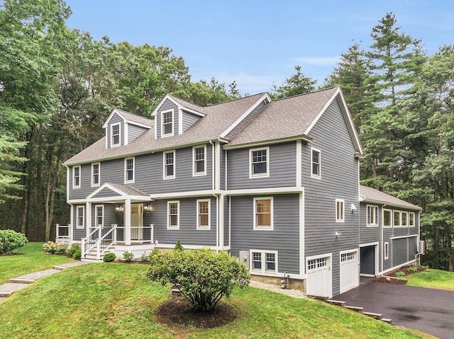 view of front of home featuring a garage, a front yard, and covered porch