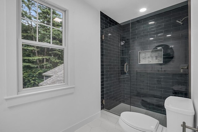 bathroom featuring tile patterned floors, a shower with door, and toilet