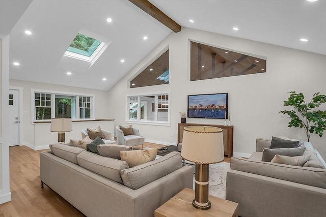 living room featuring high vaulted ceiling, beam ceiling, a skylight, and light hardwood / wood-style floors