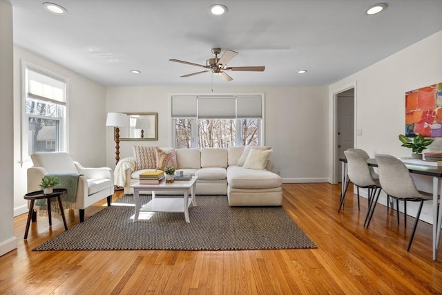 living area featuring plenty of natural light, light wood-style floors, recessed lighting, and baseboards