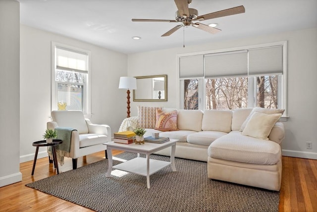 living area featuring wood finished floors, recessed lighting, a healthy amount of sunlight, and baseboards