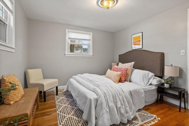 bedroom with baseboards and wood finished floors