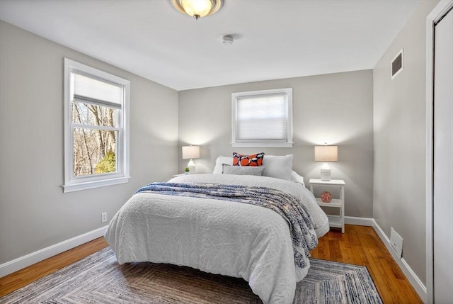 bedroom featuring visible vents, baseboards, and wood finished floors