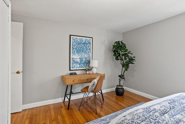 bedroom with baseboards and wood finished floors