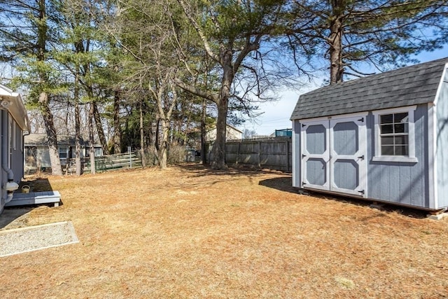 view of yard with an outdoor structure, fence, and a shed