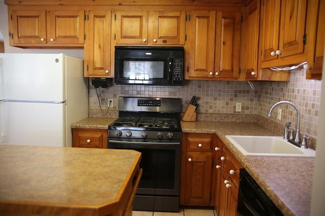 kitchen featuring sink, black appliances, tasteful backsplash, and light tile patterned flooring