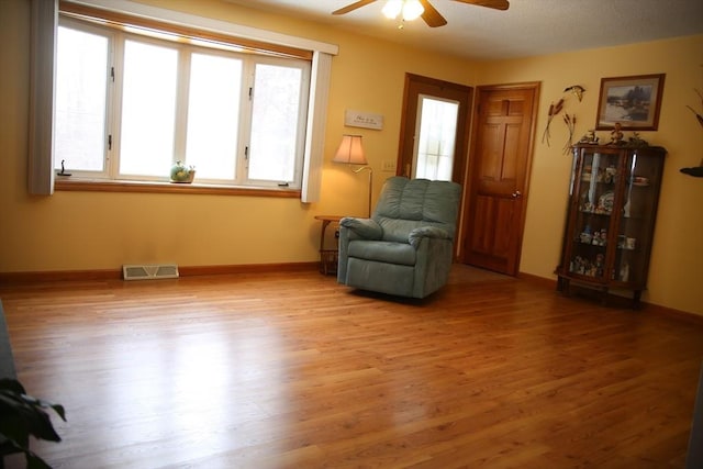 living area featuring hardwood / wood-style flooring and ceiling fan