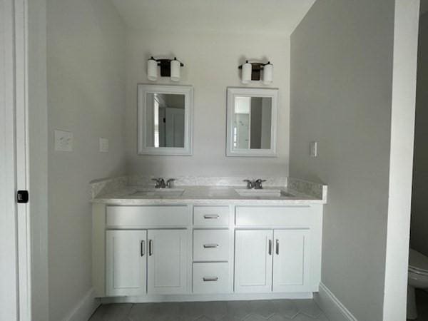 bathroom featuring tile patterned flooring, vanity, and toilet