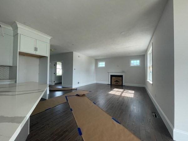 unfurnished living room featuring dark wood-type flooring