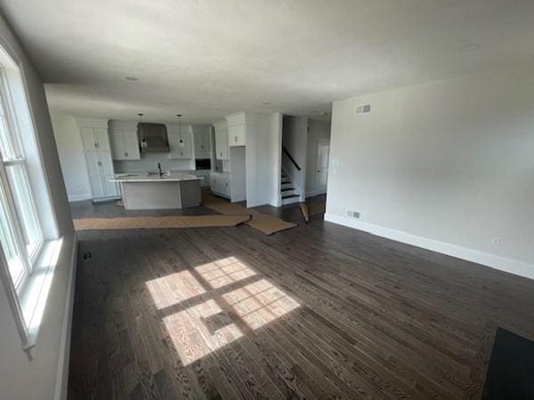 unfurnished living room featuring dark hardwood / wood-style flooring and sink