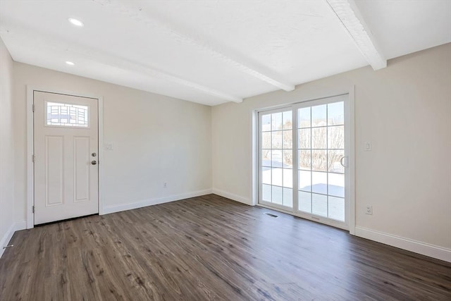 foyer featuring beamed ceiling, dark wood-type flooring, and a wealth of natural light