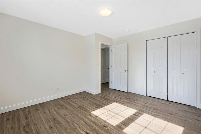 unfurnished bedroom featuring hardwood / wood-style flooring and a closet