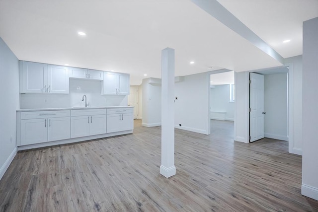 basement with sink and light wood-type flooring