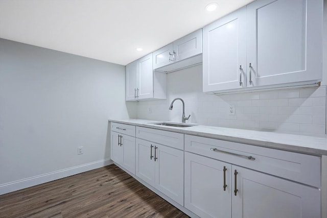 kitchen featuring sink, white cabinetry, light stone counters, tasteful backsplash, and dark hardwood / wood-style flooring