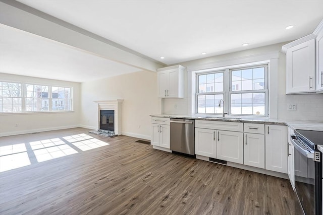 kitchen featuring sink, white cabinetry, dark hardwood / wood-style flooring, stainless steel appliances, and decorative backsplash