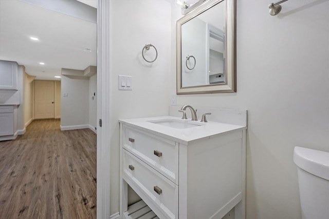 bathroom featuring vanity, toilet, and hardwood / wood-style floors