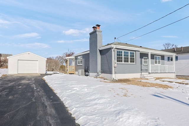 view of front of property with a garage, an outdoor structure, central air condition unit, and a porch