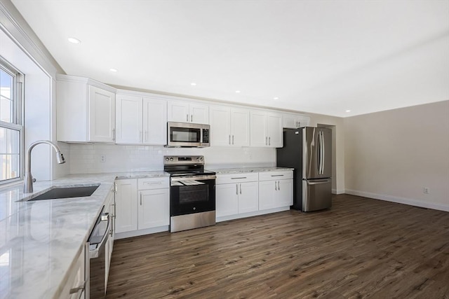 kitchen featuring white cabinetry, sink, stainless steel appliances, and light stone countertops