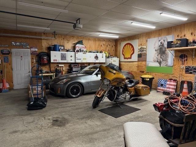 625 Middleboro Ave, Taunton, MA 02718 - garage with wood walls and a garage door opener