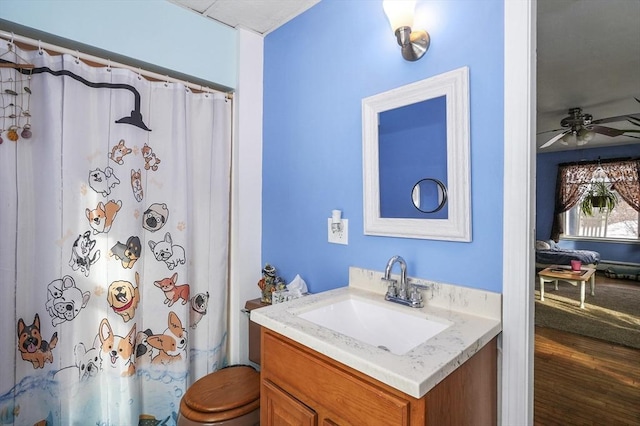 bathroom featuring wood-type flooring, ceiling fan, a shower with curtain, and vanity