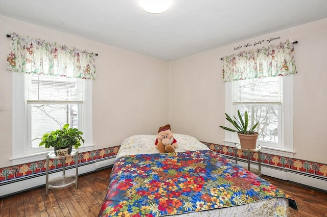 bedroom with baseboard heating, dark hardwood / wood-style flooring, and multiple windows