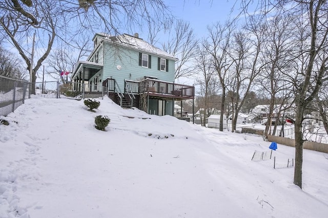 snow covered property with a deck