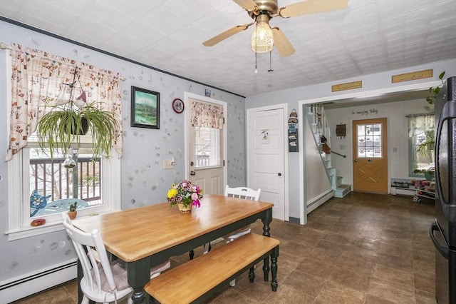 dining area with a wealth of natural light, ceiling fan, and a baseboard radiator