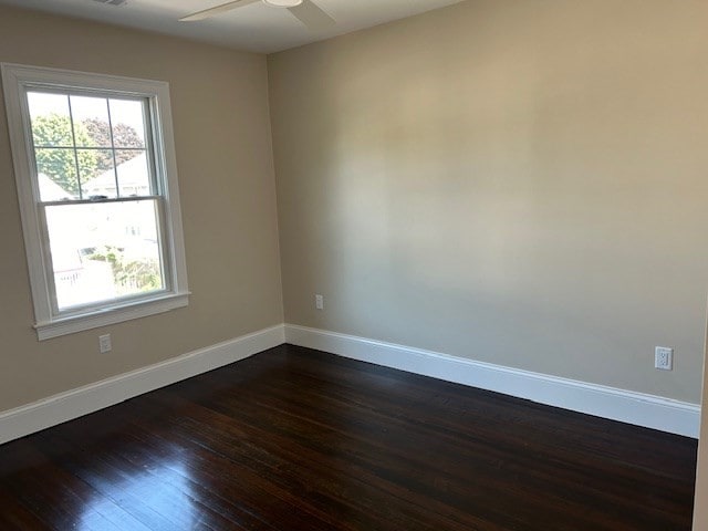 empty room featuring ceiling fan and dark hardwood / wood-style flooring