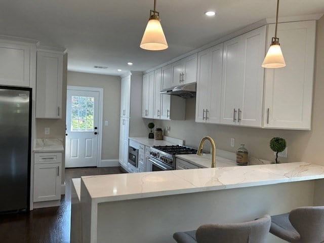 kitchen with light stone countertops, kitchen peninsula, hanging light fixtures, stainless steel appliances, and a breakfast bar