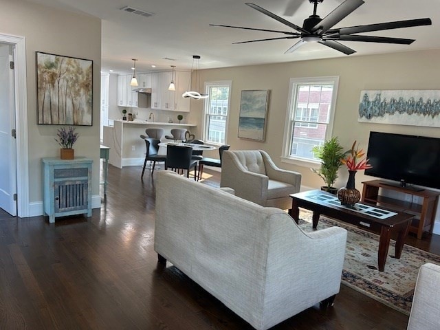 living room featuring ceiling fan and dark hardwood / wood-style flooring