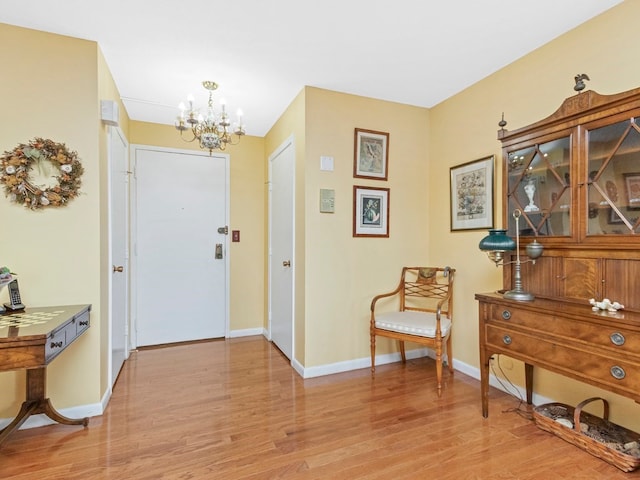 foyer entrance with light hardwood / wood-style floors and a chandelier