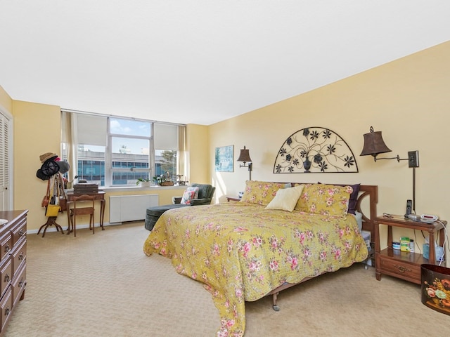 bedroom featuring radiator and light colored carpet