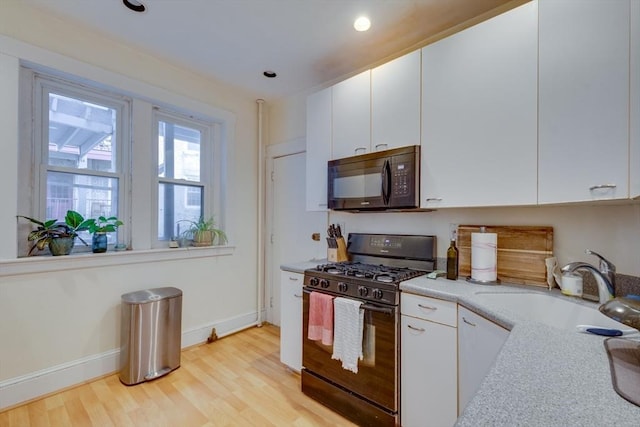60 Dwight Unit 2, Brookline, MA 02446 - kitchen with black appliances, a sink, light wood-type flooring, white cabinetry, and recessed lighting