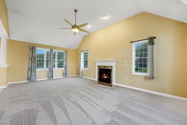 unfurnished living room with a premium fireplace, a ceiling fan, vaulted ceiling, carpet flooring, and baseboards