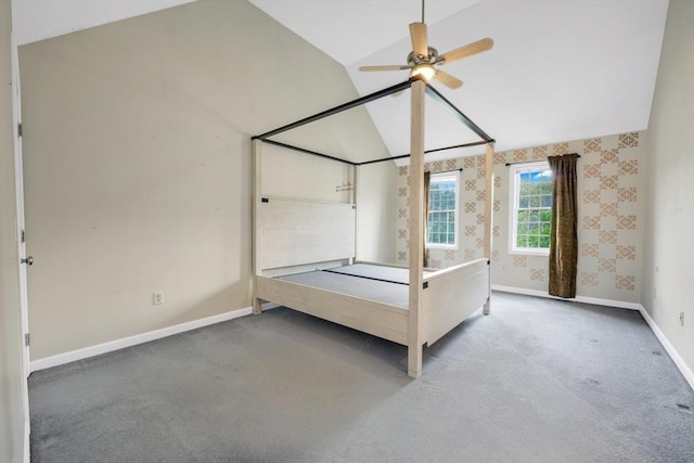 unfurnished bedroom featuring lofted ceiling, carpet floors, baseboards, and wallpapered walls